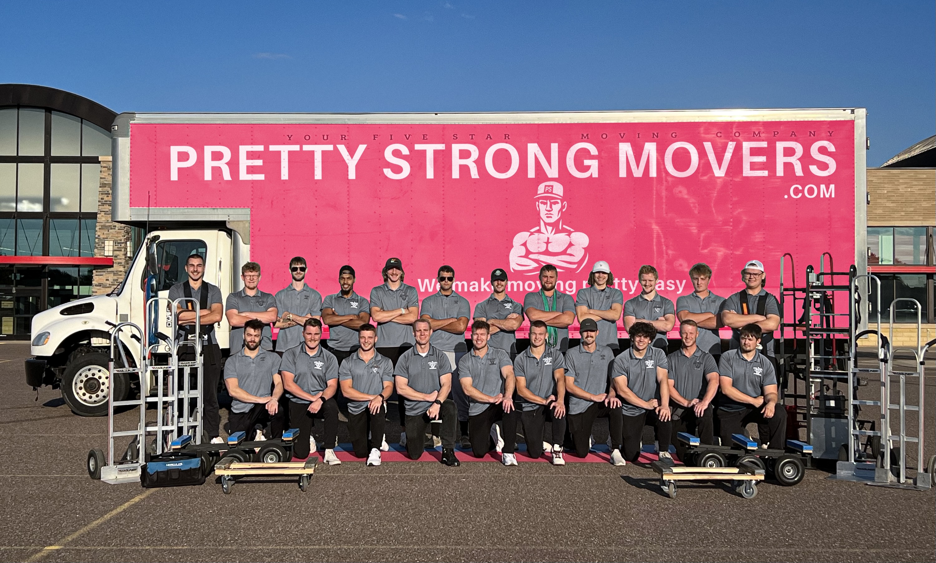 The Pretty Strong Movers crew in front of the pink moving truck, serving Madison, Wisconsin