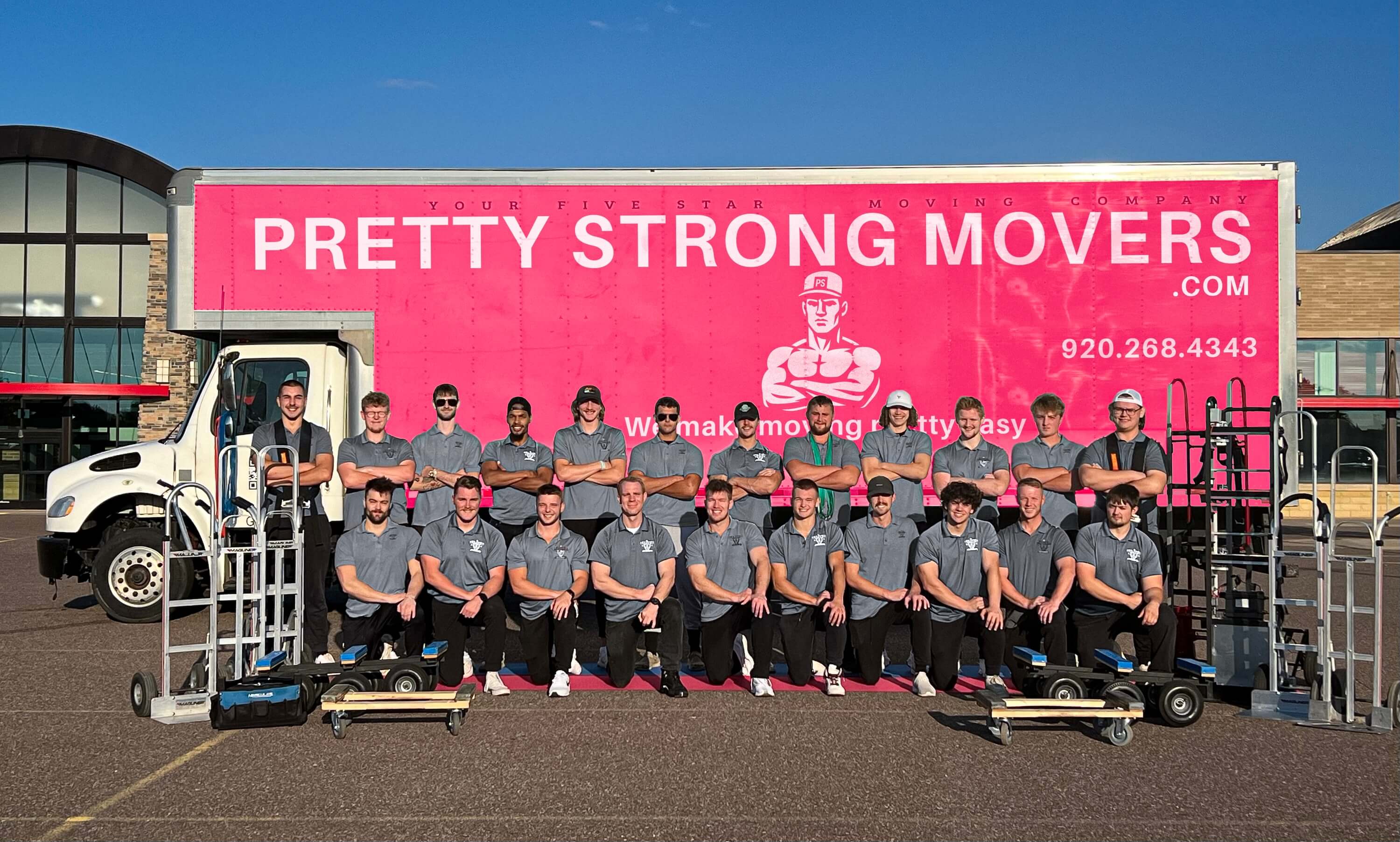 Pretty Strong Movers crew in front of pink moving truck